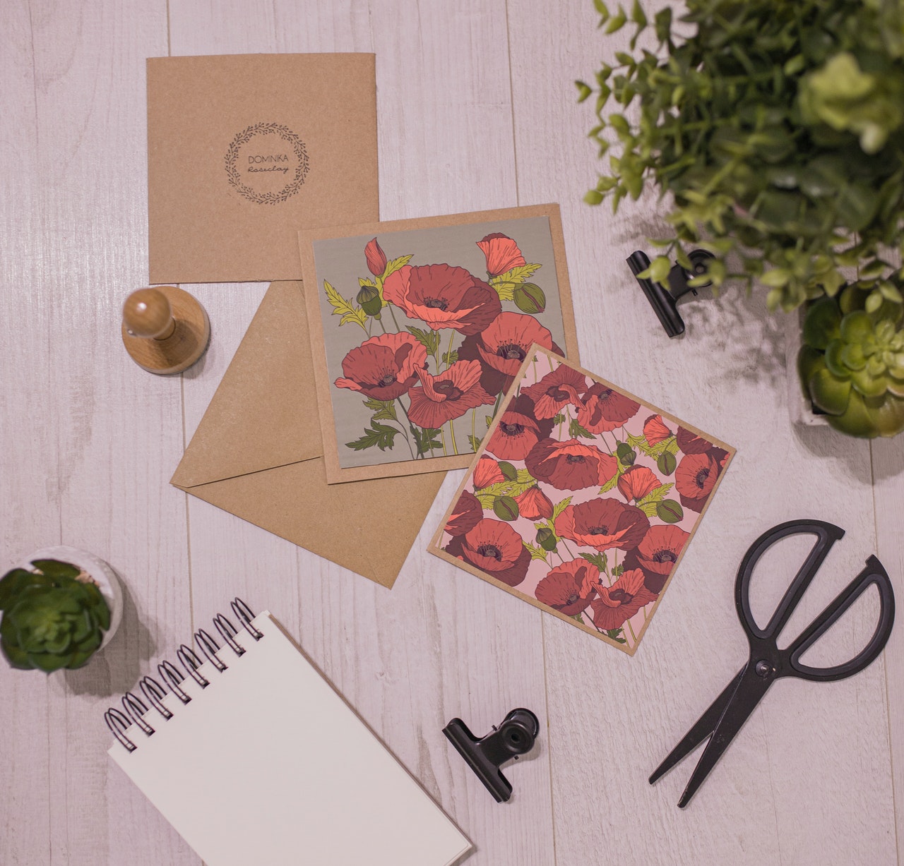 Handmade invitation gift card with flowers and stationery near houseplants