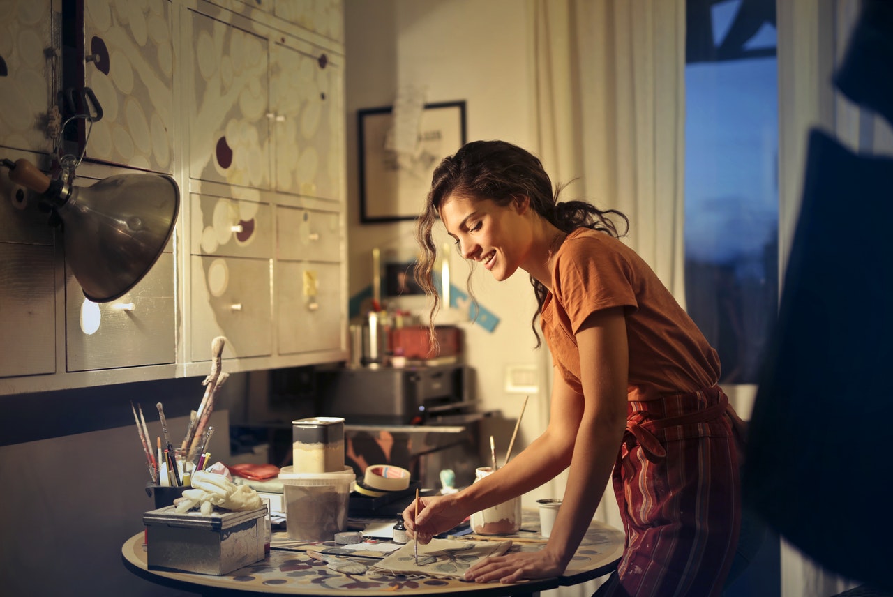 woman happily painting on her desk