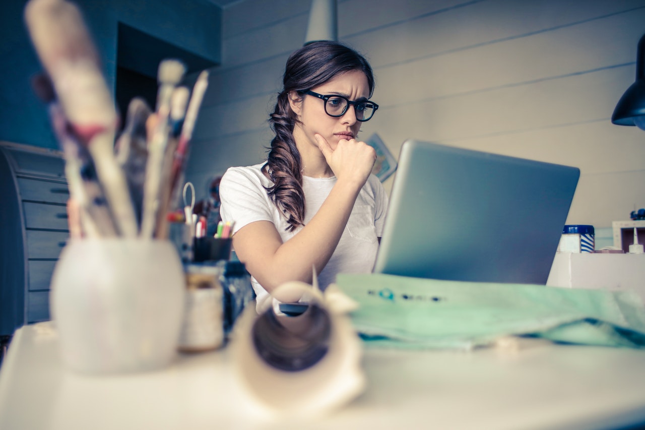 woman looking on laptop stressed